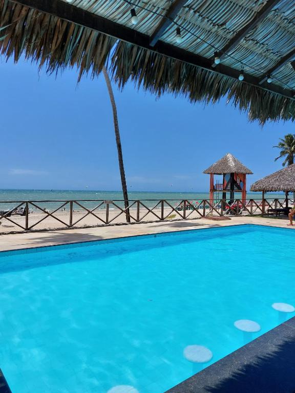 a swimming pool with the beach in the background at Eco Paradise 213 in Cumbuco