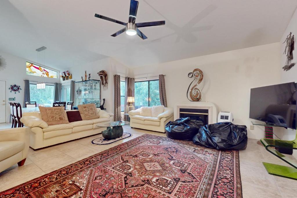 a living room with two couches and a flat screen tv at Southwestern Sun Sanctuary in Sedona