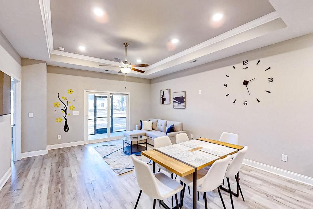 a dining room with a table and a clock on the wall at Old Bryan Salento - A in Myrtle Beach