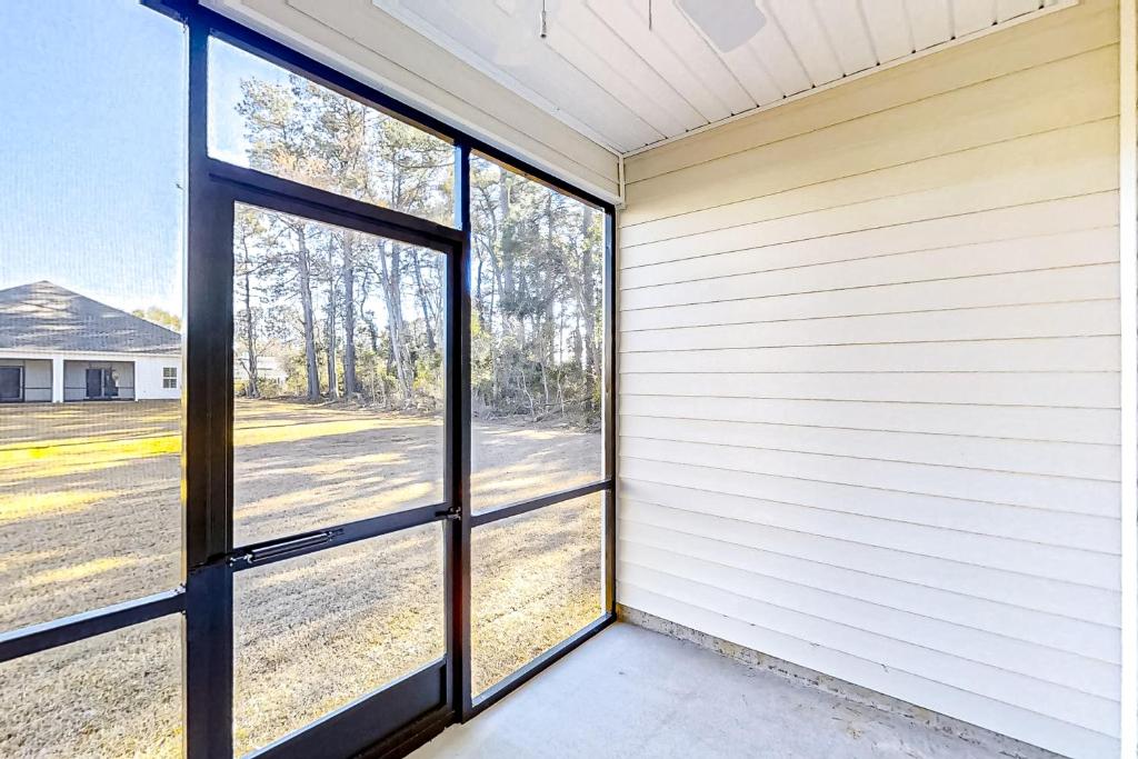 an empty house with doors to a yard at Old Bryan Salento - A in Myrtle Beach