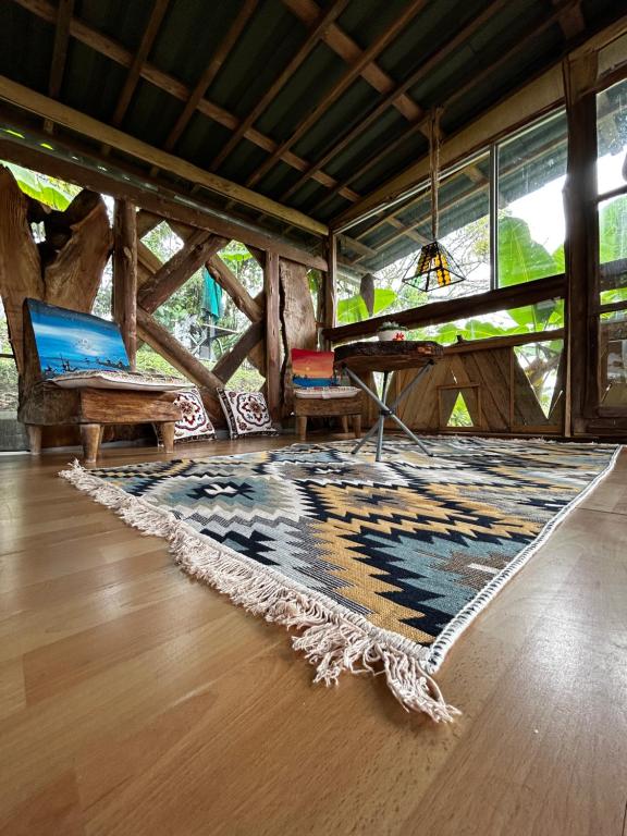 un soggiorno con tappeto e tavolo di "refugio entre montañas" lalomaecolodge a Dosquebradas