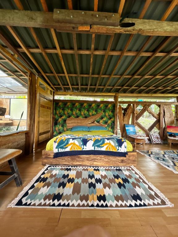 una camera con un letto e un tappeto sul pavimento di "refugio entre montañas" lalomaecolodge a Dosquebradas