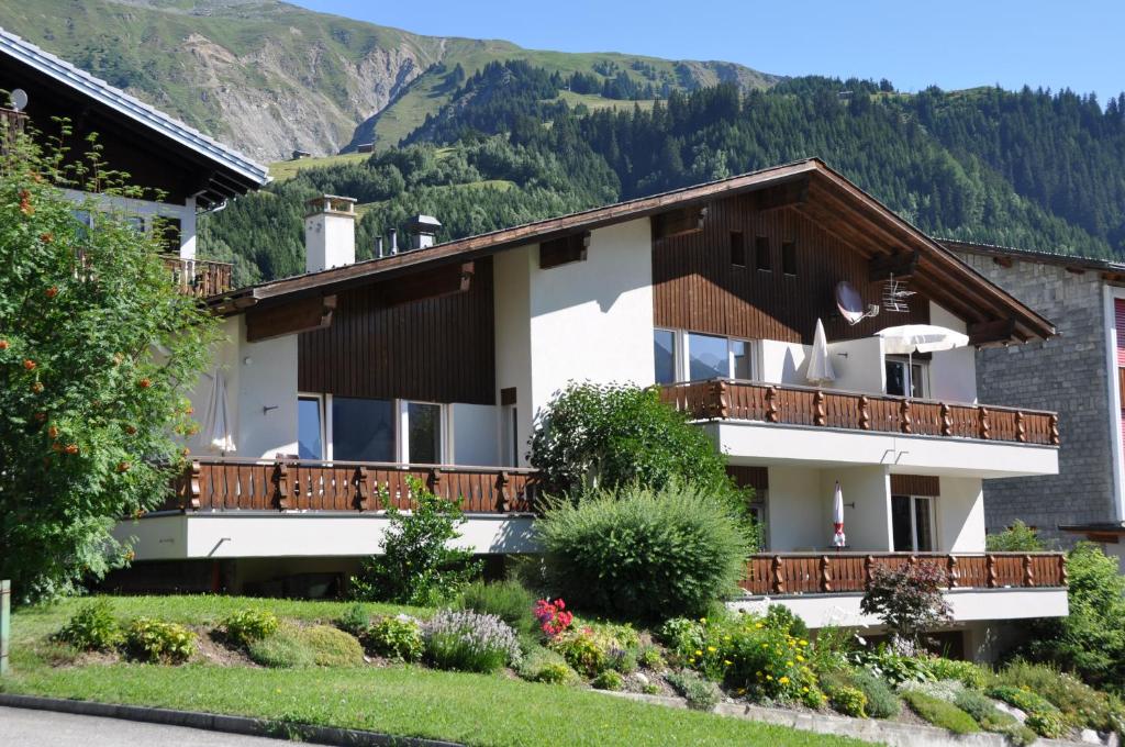 a building with a balcony with mountains in the background at Casa La Roda, Via da Scola 2 in Sedrun