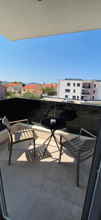 a patio with a table and two chairs on a balcony at Adriatic Wave Residence in Brodarica