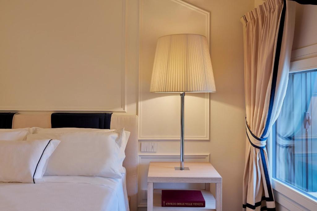sypialnia z łóżkiem, lampą i oknem w obiekcie Casa Pierdonà w mieście Valdobbiadene
