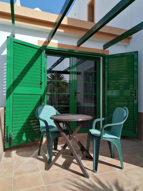 a patio with a wooden table and two chairs at Appartamento Puerta del Sol in Caleta De Fuste