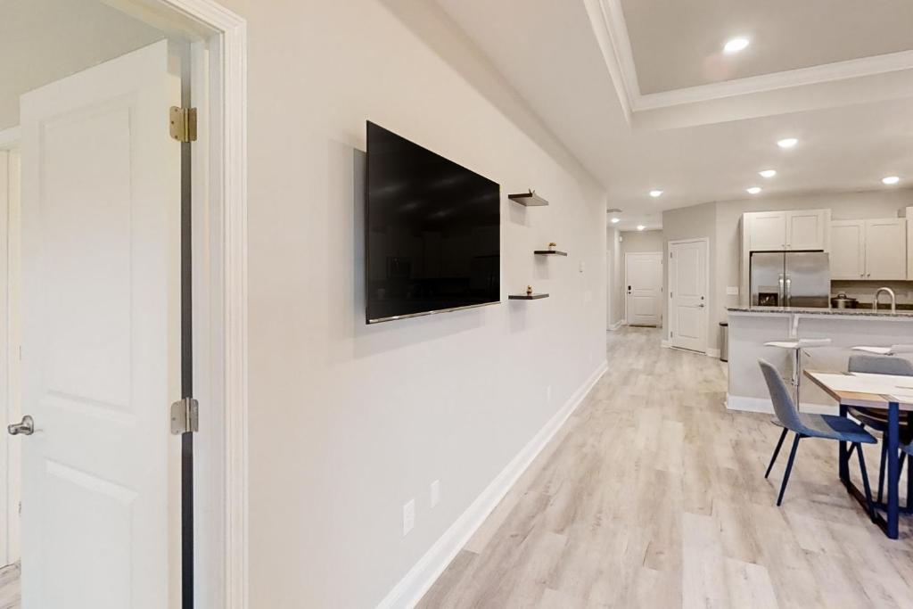 a living room with a table and a television on a wall at Old Bryan Salento - B in Myrtle Beach
