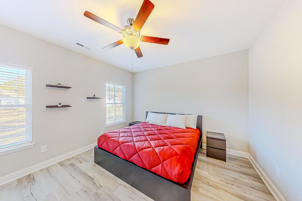 a bedroom with a red bed and a ceiling fan at Cocora on Church Street - B in Myrtle Beach