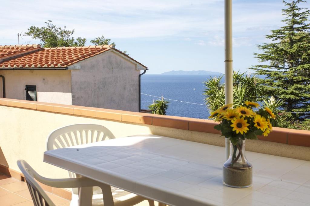 d'une table et de chaises sur un balcon avec vue sur l'océan. dans l'établissement Bougainvillea Primo Piano - Goelba, à Zanca