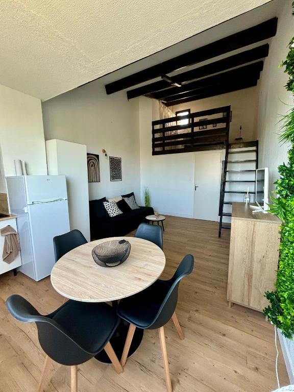 un salon avec une table, des chaises et un canapé dans l'établissement Home, au Cap d'Agde