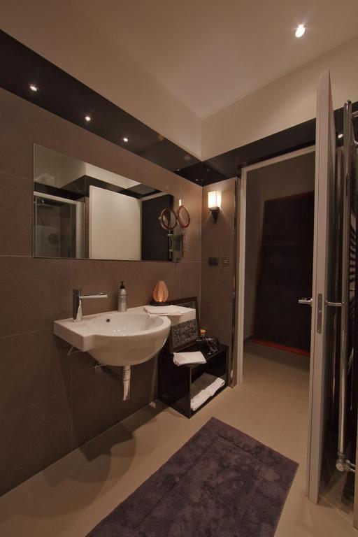 W łazience znajduje się biała umywalka i prysznic. w obiekcie Zenthe Small Luxury B&B w mieście Brindisi