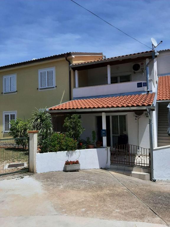 a house with a white fence in front of it at Apartments with parking space Cizici - Krk - 15415 in Malinska