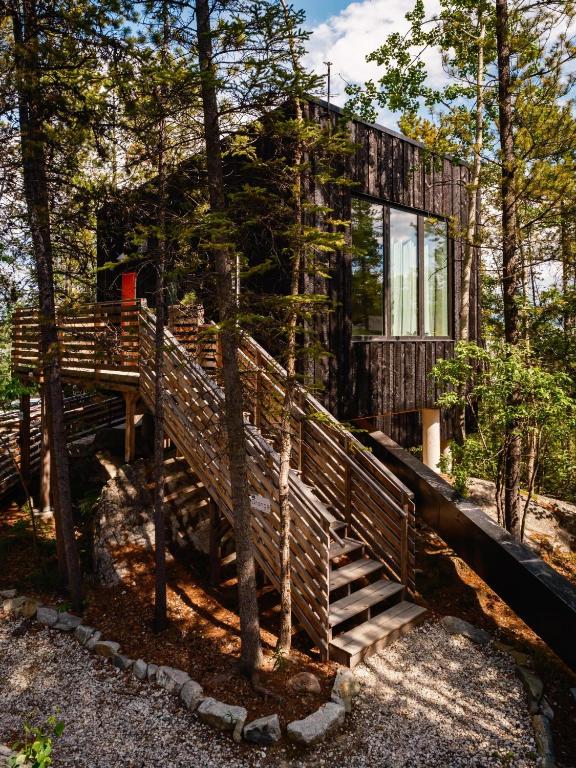 a house in the woods with a wooden staircase at Black Spruce - Orange Door in Whitehorse