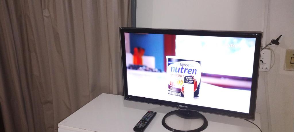a television sitting on a table with a remote control at Residencial mineiro in São Lourenço