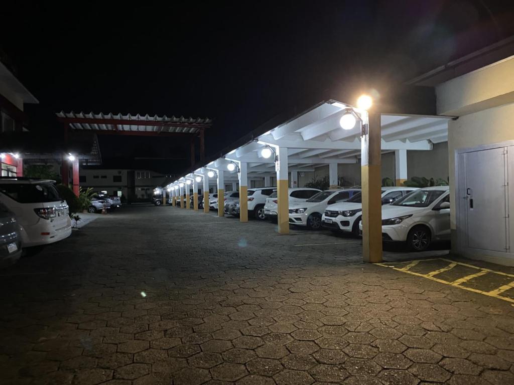 a row of cars parked in a parking lot at night at Hotel Valle Sul in Registro