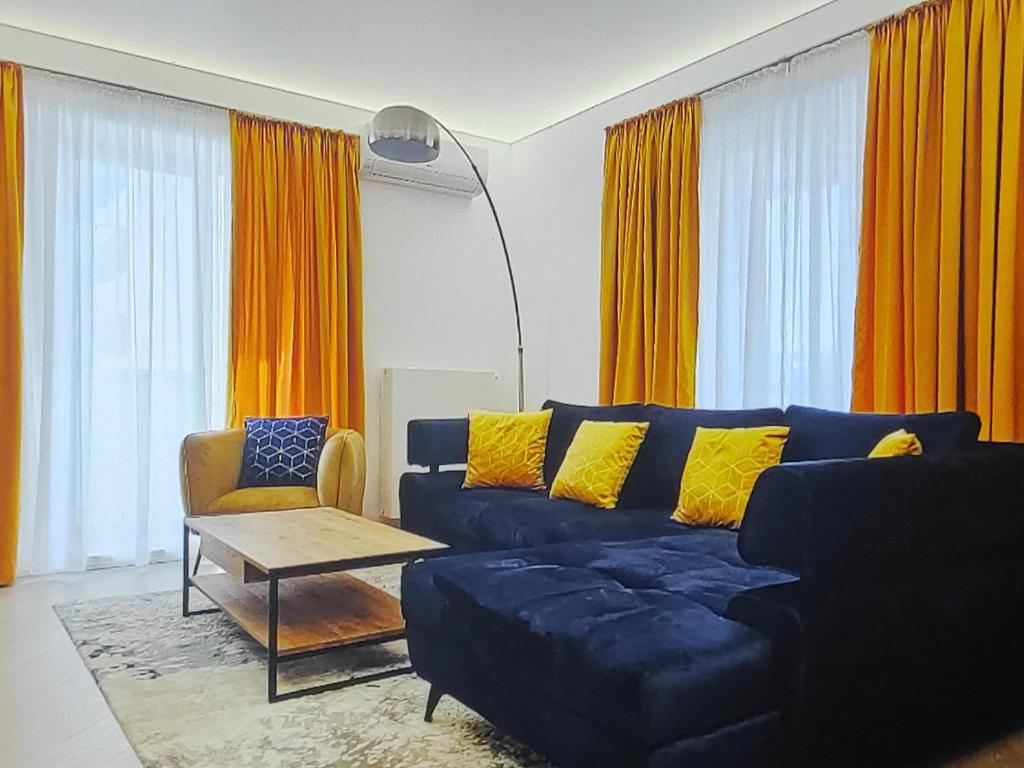 Una sala de estar con un sofá azul y cortinas naranjas. en Lazuly 2 BDR Luxury, en Varna