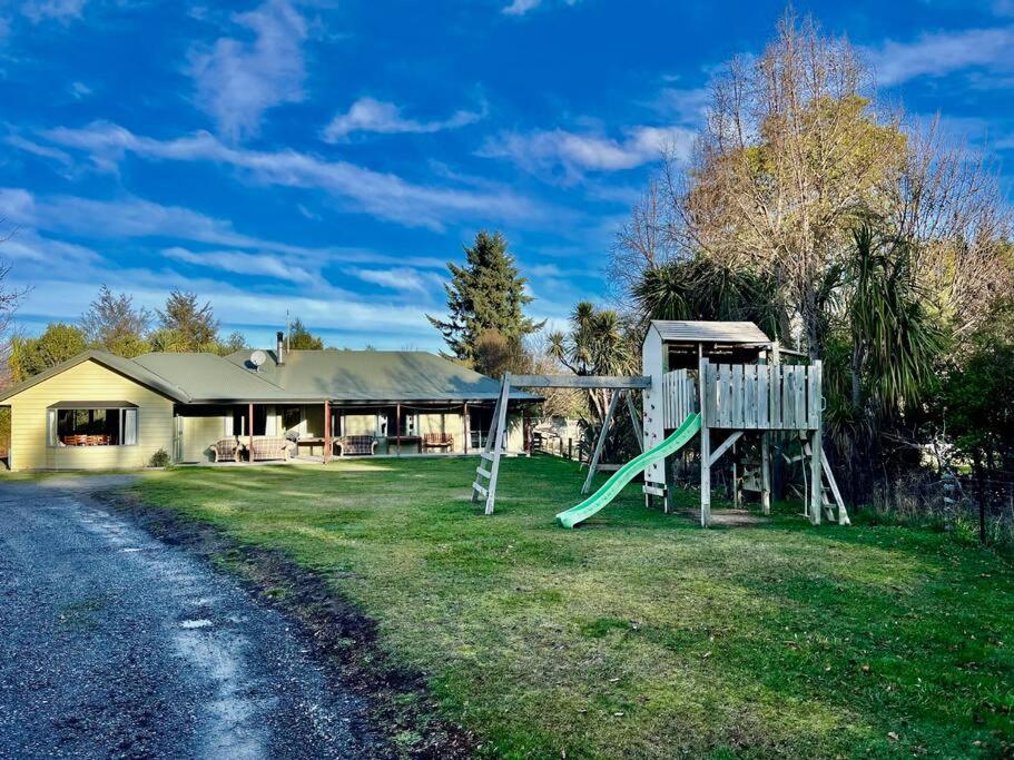 a house with a playground next to a road at Family Hideaway in Hanmer Springs