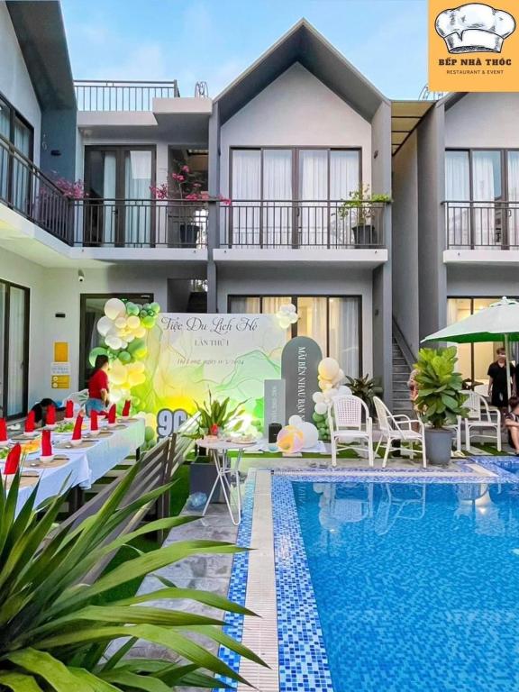 un complexe avec une piscine dotée de tables et de chaises dans l'établissement Chuỗi Villa Tuần Châu 8 Ngủ - Bể bơi riêng - sân vườn - BBQ, à Hạ Long