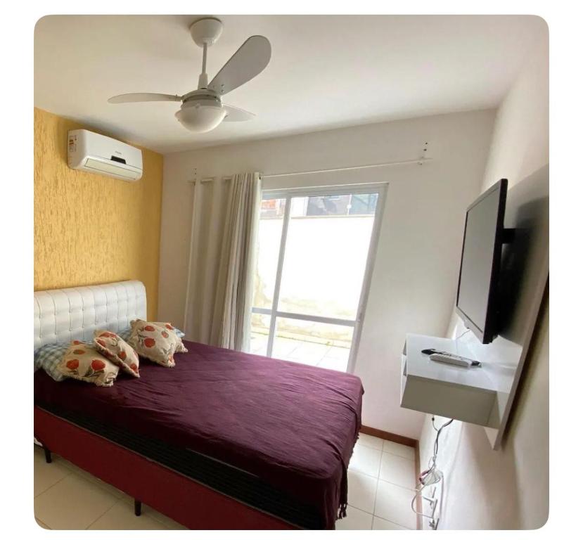 une chambre avec un lit, une télévision et une fenêtre dans l'établissement Apartamento canto da Prainha, à Arraial do Cabo