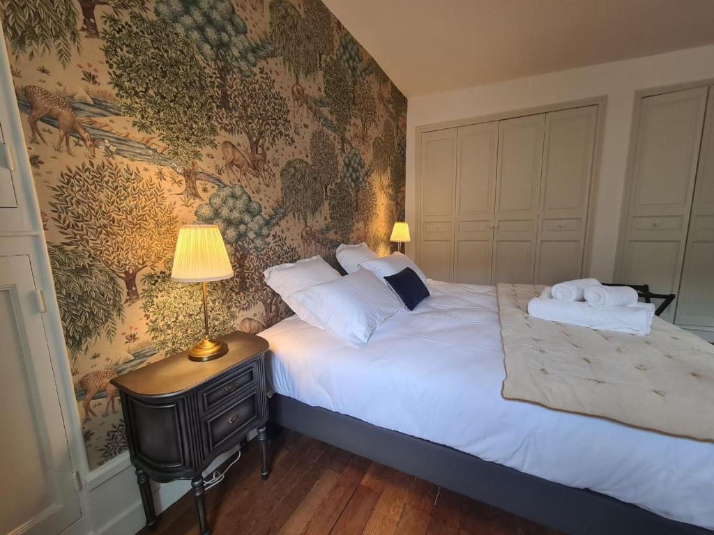 una camera da letto con un letto e una lampada su un tavolo di Chambre "Diane" avec salle d'eau privative et petit-déjeuner à Châteauroux - FR-1-591-602 a Châteauroux