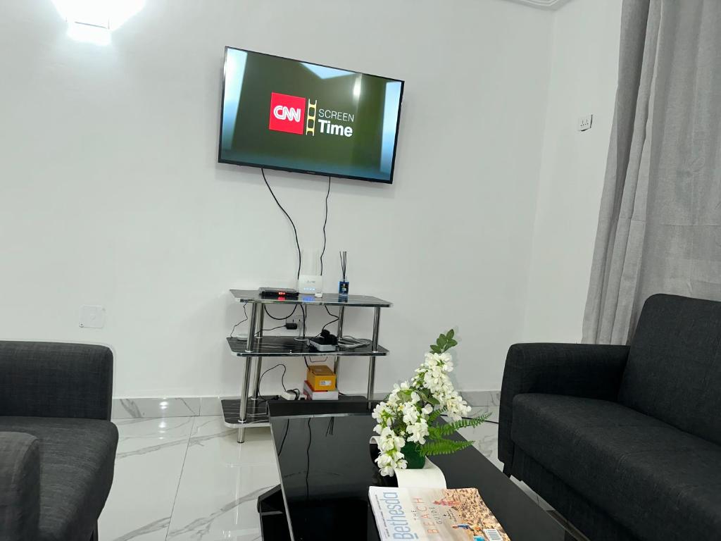 een woonkamer met een flatscreen-tv aan de muur bij Costal Vibe Escapes in Monrovia