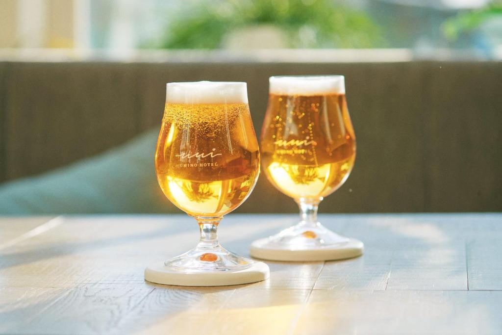 two glasses of beer sitting on a table at Hayama Umino Hotel in Hayama