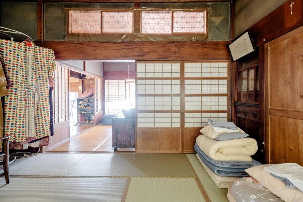 Postel nebo postele na pokoji v ubytování ゲストハウス+カフェわ　１日１組限定！ 築１００年の農家の古民家で宿泊体験、薪でお風呂沸かせます。焚き火もできます。