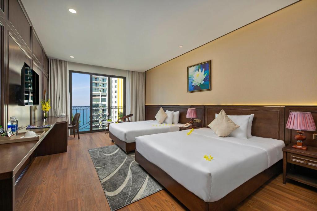 Giường trong phòng chung tại Golden Lotus Hotel Da Nang - Rooftop Bar Sea View