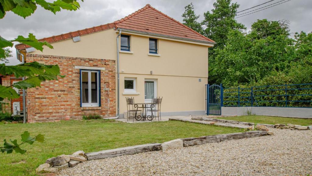 a small white house with a table in a yard at Les volets bleus & les p'tits cailloux in Brévonnes