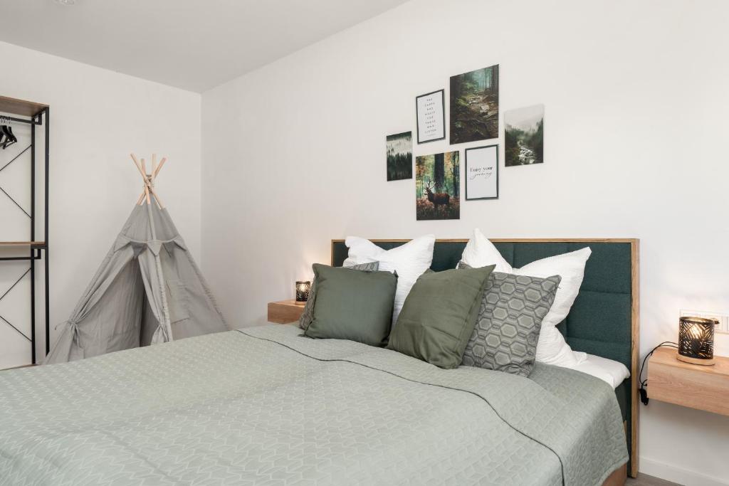 a bedroom with a bed with green and white pillows at Livesto Apartments im Zentrum Bad Driburgs - Modern, Parkplatz, Terrasse, Switch, SmartTV für Familien und B2B in Bad Driburg