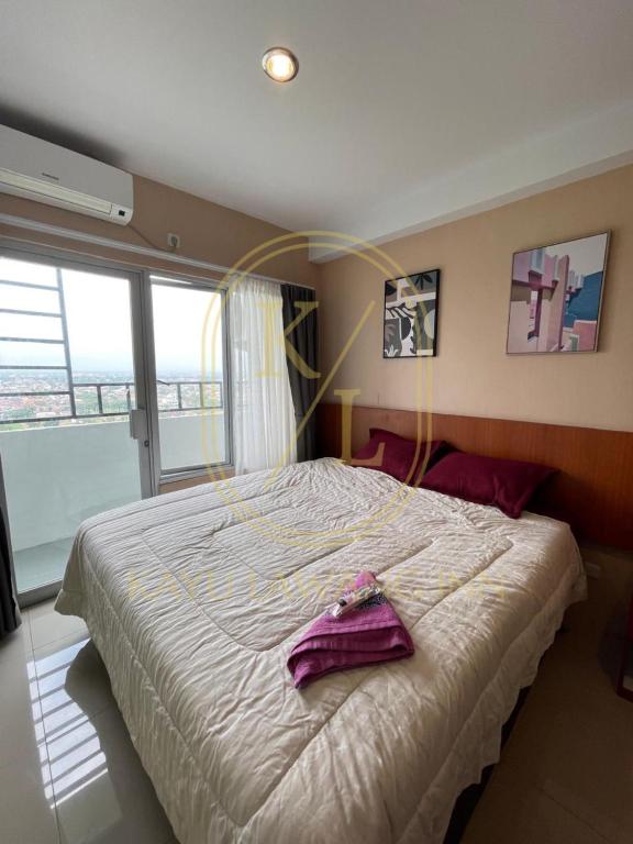Postel nebo postele na pokoji v ubytování SkyView Apartment By Kayu Lawang