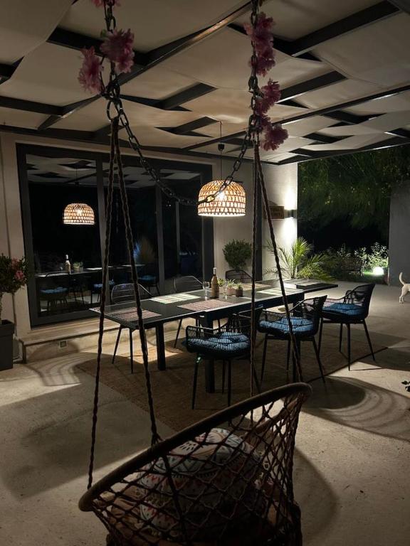a patio with a swing with a table and chairs at Villa secrecy in Lixouri