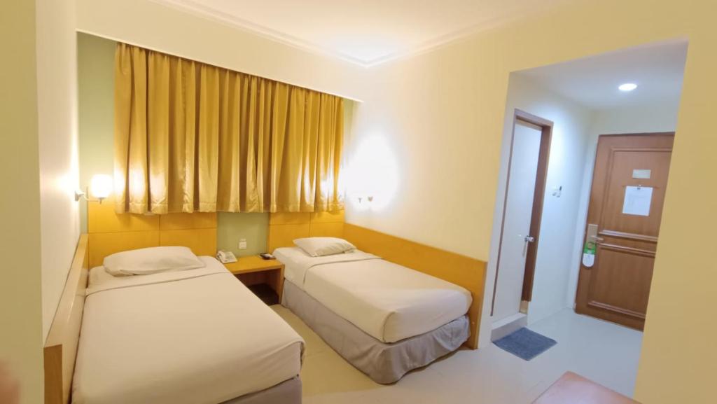 Postel nebo postele na pokoji v ubytování Hotel Wisata