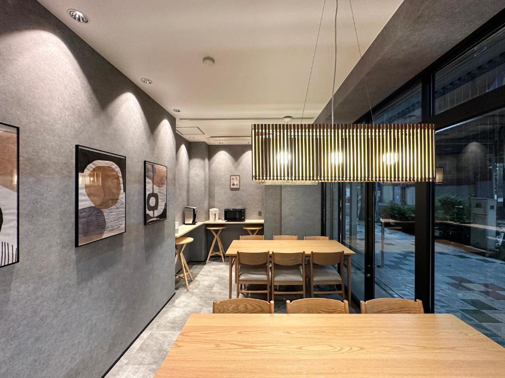 a dining room with a table and a chandelier at Osaka Ebisu Hotel in Osaka