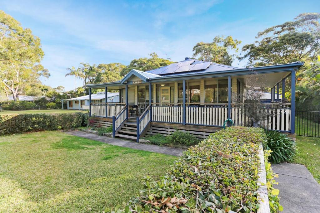 a house with a porch and a yard at Lovely Pet Friendly Beach House in Hawks Nest
