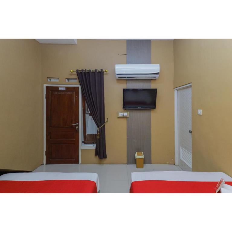 Postel nebo postele na pokoji v ubytování Reddoorz Syariah at House Of Melati Kepanjen