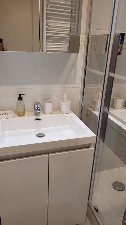 une salle de bain blanche avec un lavabo et une douche dans l'établissement Studio, à Cannes