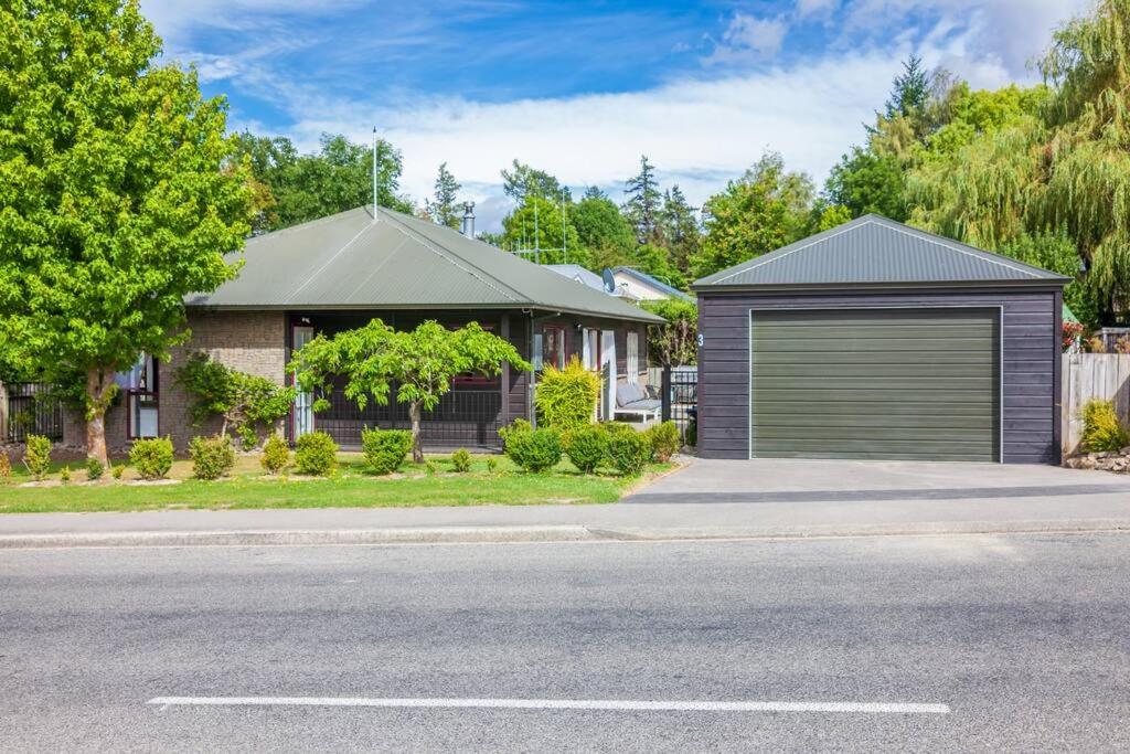 a house with a garage on the side of a street at Hanmer Four Seasons in Hanmer Springs