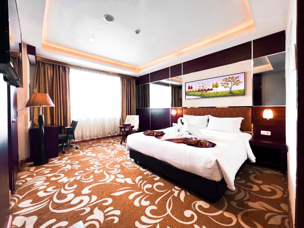 una camera d'albergo con un letto grande e una grande finestra di Batam City Hotel a Nagoya