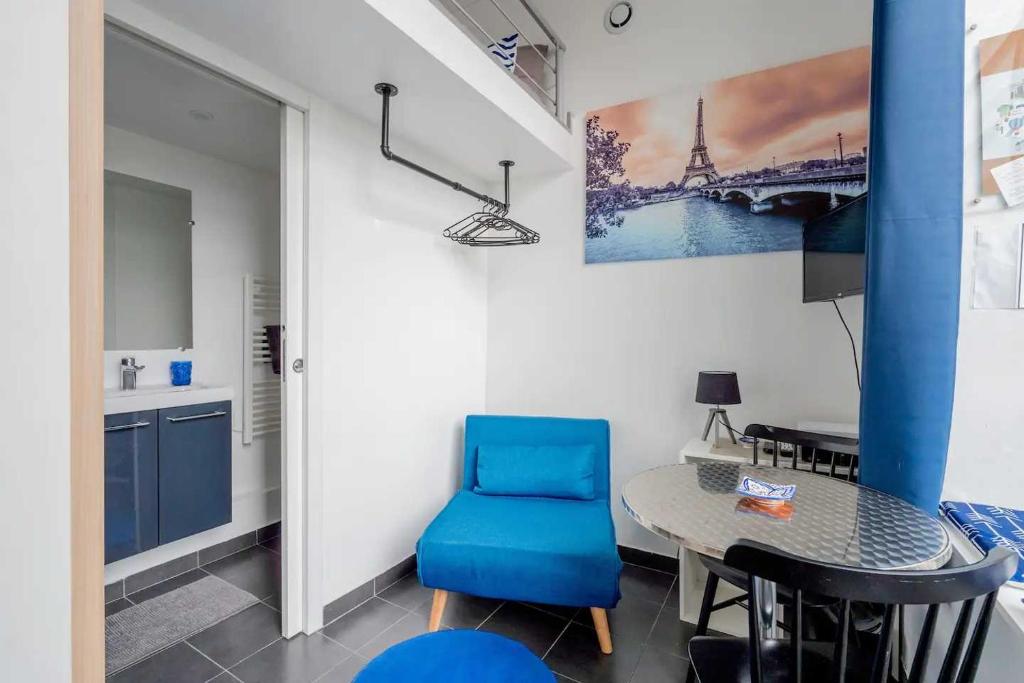 une salle à manger avec une chaise bleue et une table dans l'établissement Authentic studio - 2P - Gare de l'Est, à Paris