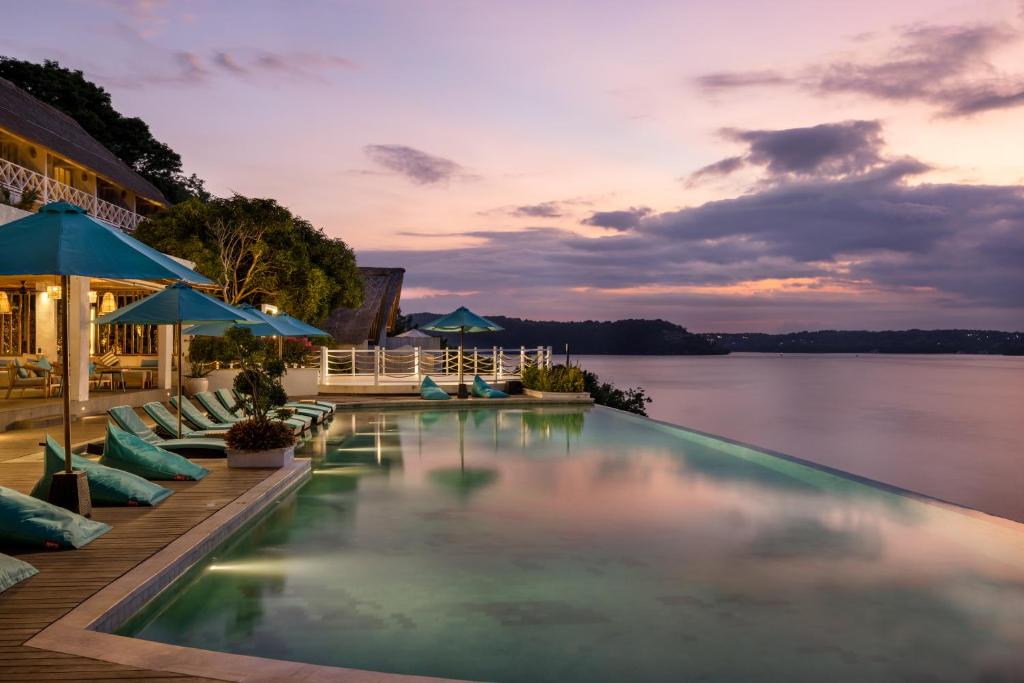 a pool at a resort with a view of the water at Pramana Natura Nusa Penida in Nusa Penida