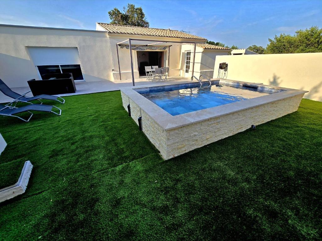 une cour avec une piscine sur gazon dans l'établissement Evasion de charme, à Saint-Marcel-dʼArdèche