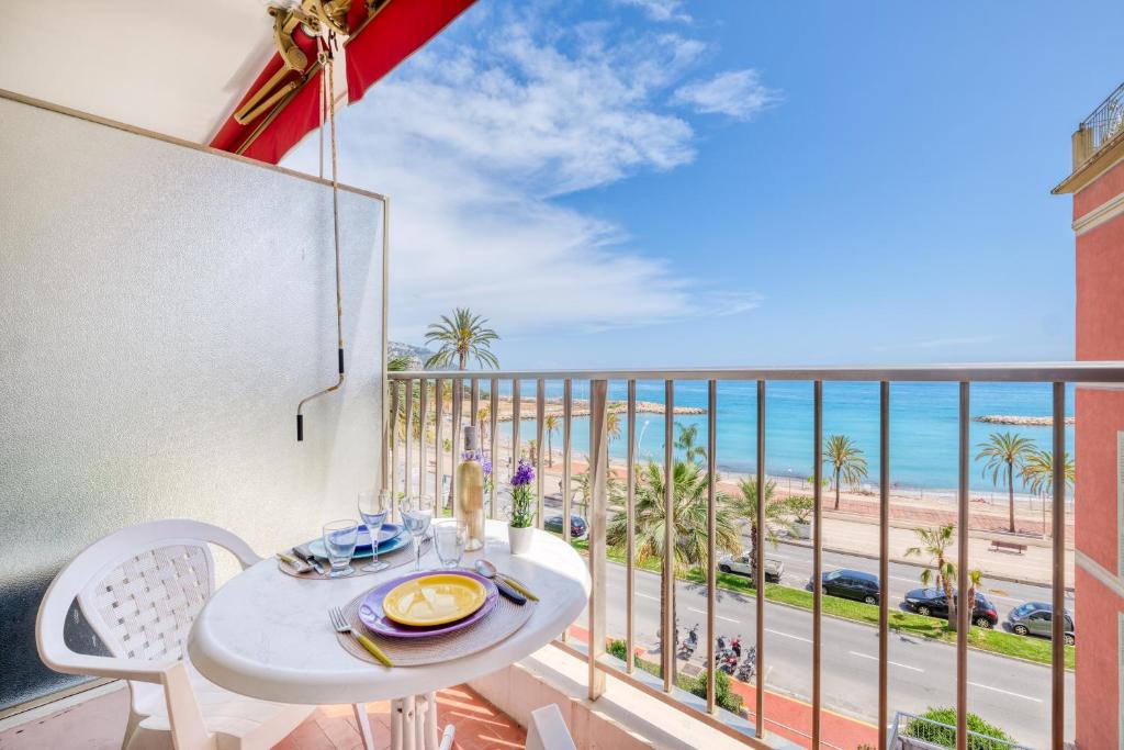 une table et des chaises sur un balcon avec vue sur la plage dans l'établissement Garavan Studio 13 - Happy Rentals, à Menton
