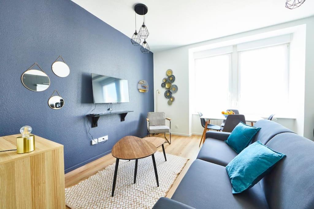 - un salon avec des murs bleus et un canapé bleu dans l'établissement BM-0 Appartement chaleureux F2 au RDC à Mulhouse - 1 à 4 pers, à Mulhouse