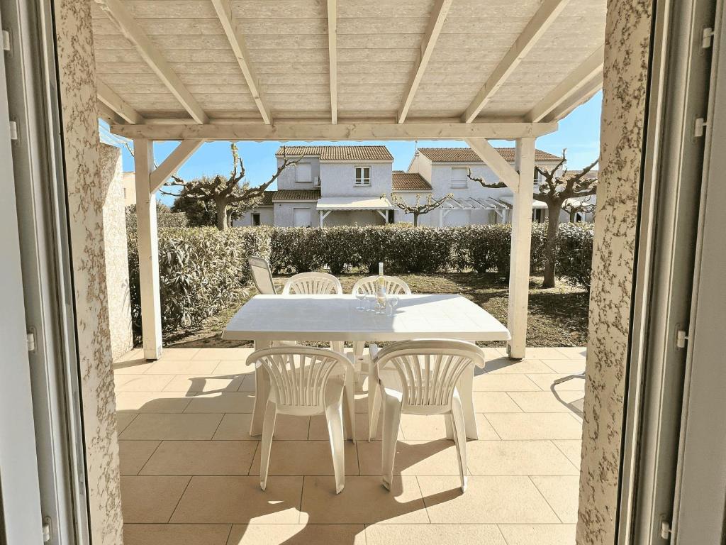 une table blanche et des chaises sur une terrasse dans l'établissement La BénéCIOLA, vue Mer, Box Fibre SFR, High Speed Internet, à Cervione