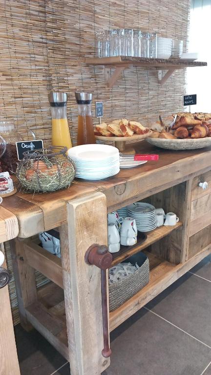 a table with plates of food and bread on it at Les Jardins de L'Ocean - Climatisé in Biscarrosse-Plage