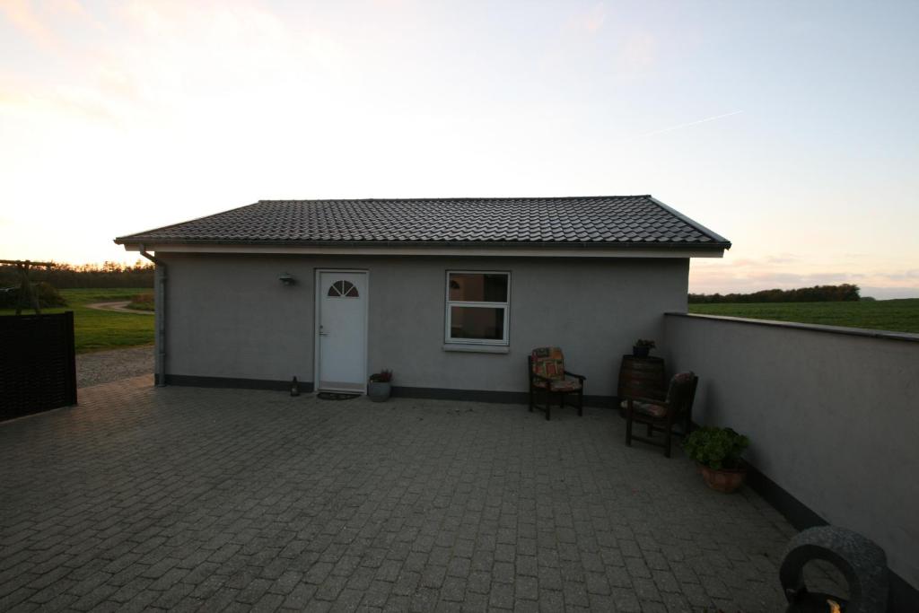 a small white house with a patio in front of it at Hellerup Bed & Breakfast in Løgstrup