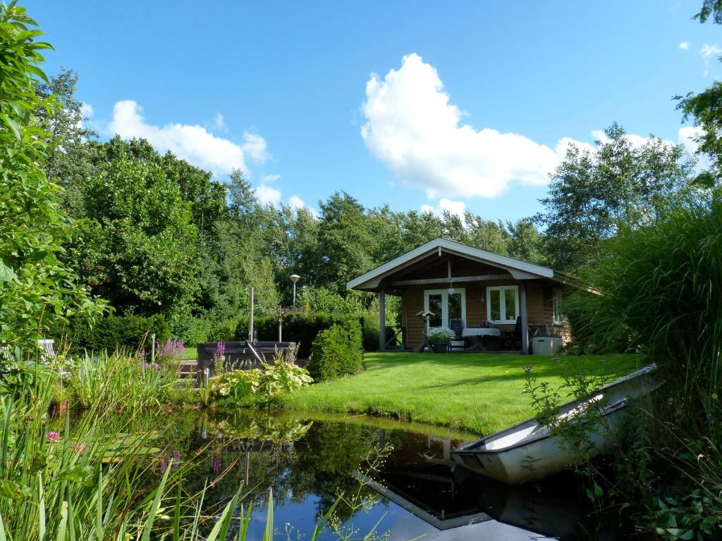 una pequeña cabaña en medio de un estanque en Gastenverblijf Klein Eden, en Olterterp