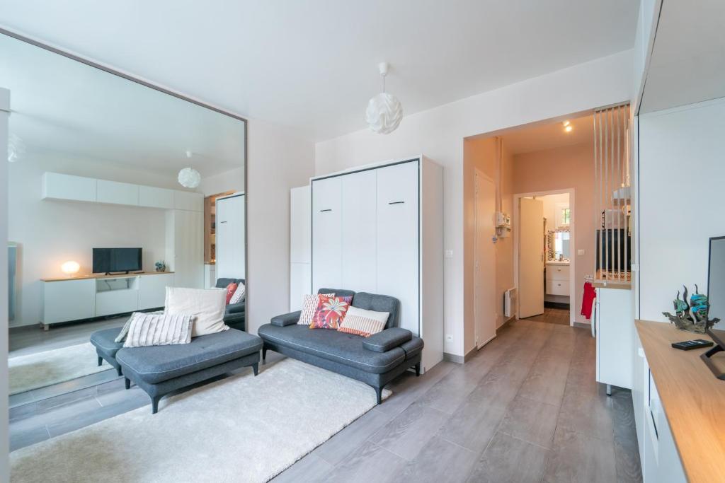 un salon avec deux chaises et une télévision dans l'établissement Miroir en Lumière - Studio à 10min du 13e Paris, à Ivry-sur-Seine