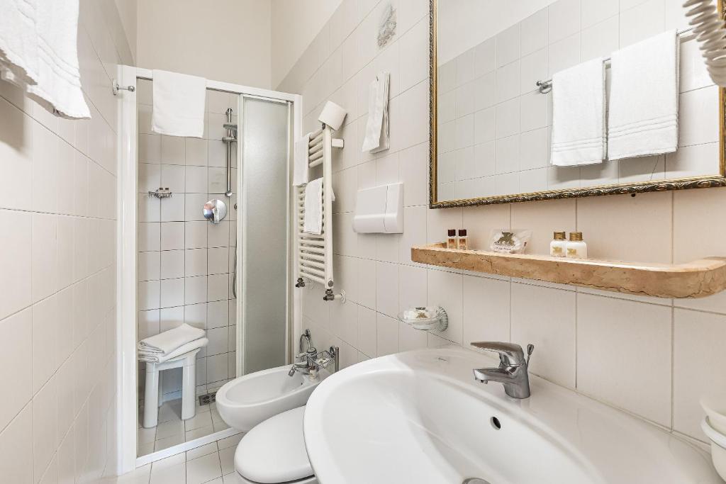 a white bathroom with a sink and a toilet at Hotel Marconi in Venice